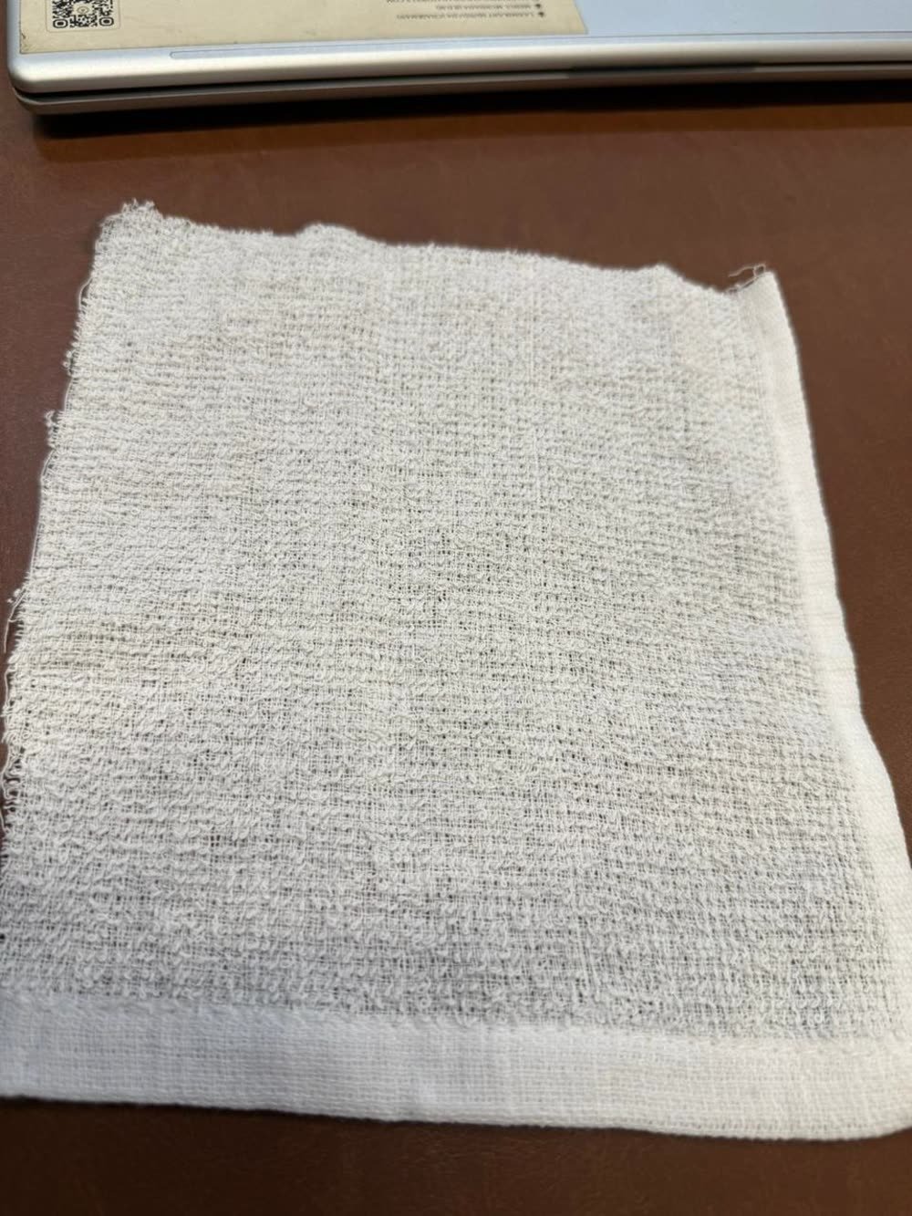 Folded oshibori towel showing loop texture and open weave